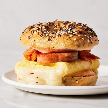 Spam, egg, cheese, and kimchi sandwich on a seeded bagel.